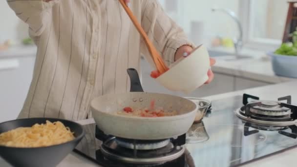 Inclinare Colpo Donna Allegra Aggiungendo Pomodori Alle Cipolle Padella Mescolando — Video Stock