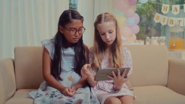 Средний Длинный Снимок Двух Детей Использующих Цифровой Планшет Смеющихся Сидя — стоковое видео