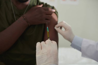 Doktorun Coronavirus 'a karşı aşısı olan şırıngayı tutarken yakın plan görüntüsü.