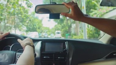 Öğretmenin direksiyon dersi alırken öğrencisinin dikiz aynasını düzeltmesine arka plan