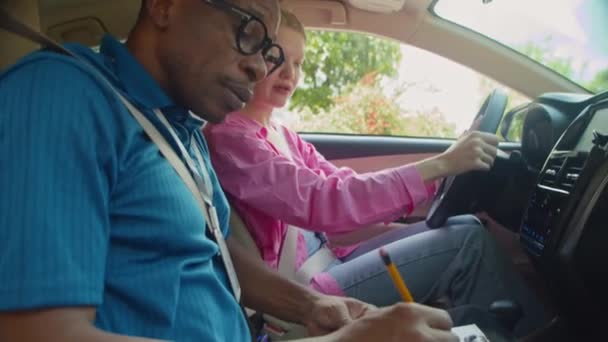Tilt Shot Instructor Filling Card Female Student Sitting Car Exam — Stock Video