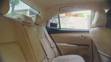 Takside arka koltukta oturan ve arkadaşına mesaj atan beyaz kadının yan görüntüsü.