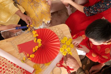 Bahar festivali için duvar süslemelerine sarı kayısı çiçekleri yapıştıran aile.