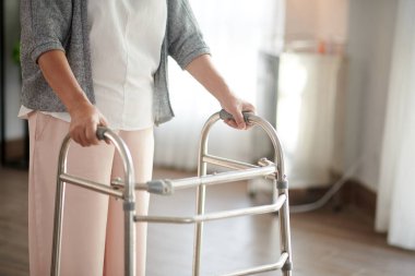 Huzurevinde dolaşırken Walker 'a yaslanan yaşlı bir kadının kesilmiş görüntüsü.