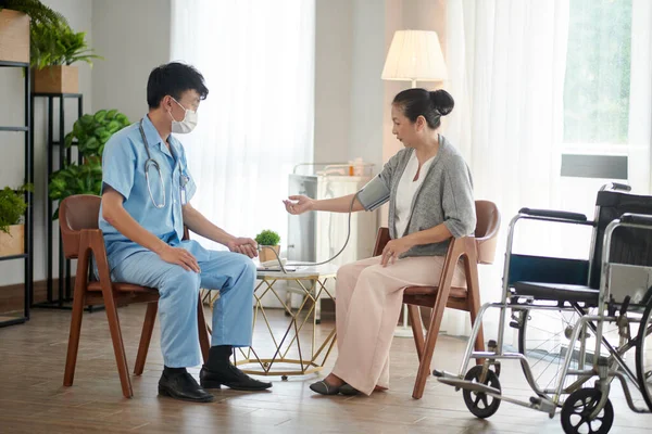 Doctor visiting senior woman at home for annual check-up