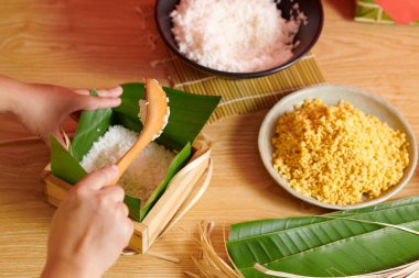 Vietnam kare keki yaparken ellerin küfü pirinç ve fasulyeyle dolduruyor.