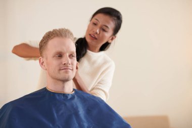 Kız arkadaşın evde genç bir adamın saçını kesiyor.