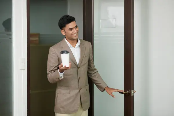 Gelukkige Indiase Ondernemer Met Kopje Take Out Koffie Opening Kantoordeur — Stockfoto