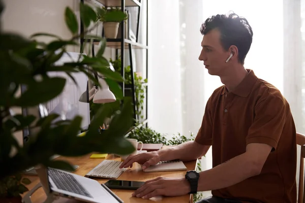 Software developer talking to team leader at online meeting when working from home