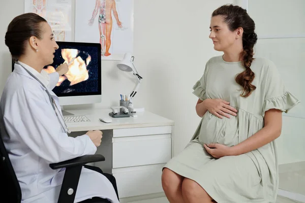 彼女の赤ちゃんの健康について話し 紫外線画像を見るために婦人科医を訪問する幸せな妊婦 — ストック写真