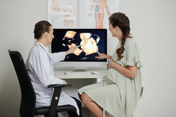 Arzt Und Schwangere Patientin Diskutieren Bild Des Babys Auf Computerbildschirm — Stockfoto