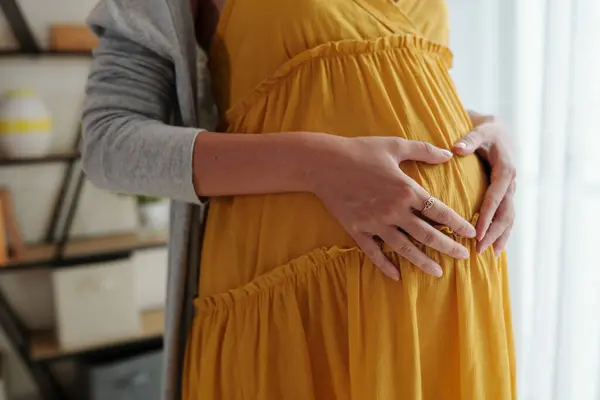 彼女の腹に手を保っている妊婦のクローズアップ画像 — ストック写真