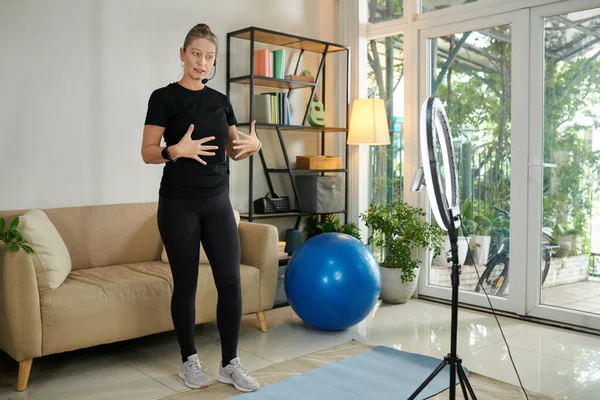 Fitness instructor recording video on how to breathe when exercising