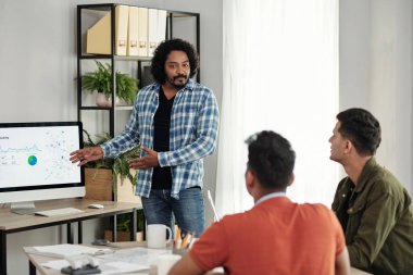 IT şirketi yöneticisi toplantıda beyaz panodaki çizelge detaylarını meslektaşlarına anlatıyor