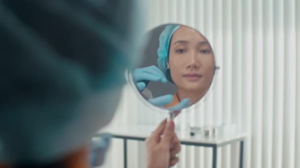 Jeune Femme Assise Clinique Regardant Dans Miroir Après Procédure Rajeunissement — Video