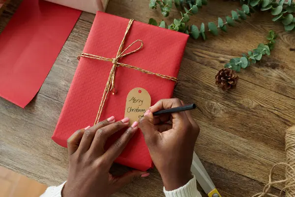 Руки Женщины Пишущей Рождественской Меткой Завернутом Подарке — стоковое фото