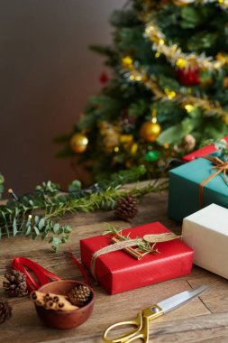 Dekorasyon için paketlenmiş Noel hediyeleri, kozalaklar ve tarçın çubukları.