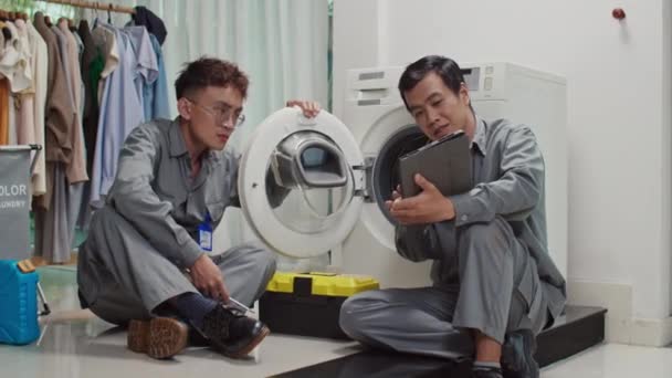 클라이언트 세탁기를 설치하는 디지털 태블릿에 지침을보고 아시아 배관공의 — 비디오
