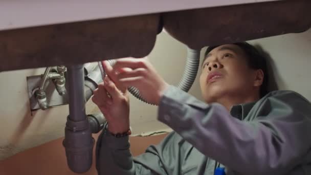 Erkek Muslukçunun Lavabonun Altındaki Plastik Boruyu Ngiliz Anahtarıyla Sıkılaştırdığı Orta — Stok video