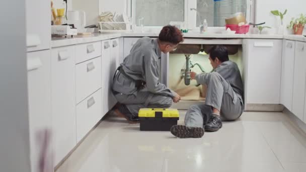 Longo Tiro Encanadores Masculinos Instalando Novos Tubos Enquanto Trabalhava Cozinha — Vídeo de Stock