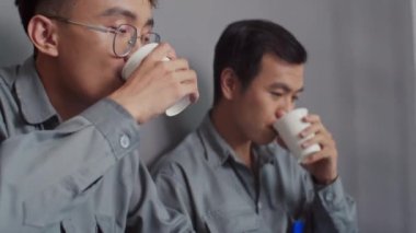 İnşaatçıların çay içme ve yenileme stratejisi hakkında konuşma odağı kablosuz dizüstü bilgisayarla yerde oturuyor