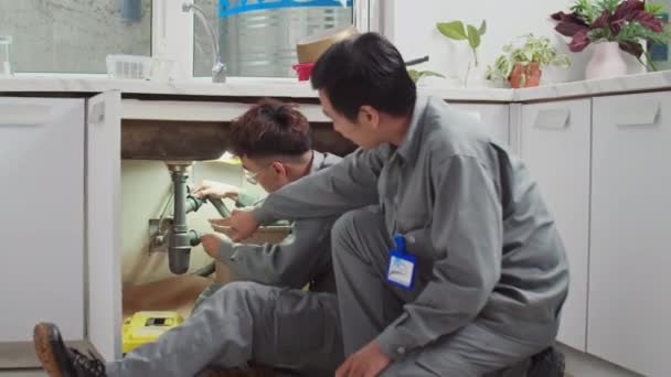 Средний Выстрел Азиатских Специалистов Мужчин Устраняющих Протекающие Трубы Раковиной Кухне — стоковое видео
