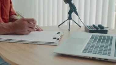 Stüdyoda ünlü biriyle röportaj yapmaya hazırlanırken, düşünceli editörün kablosuz dizüstü bilgisayara notlar yazdığı orta boy bir fotoğraf.