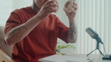 Düşünceli erkek podcaster 'ın stüdyodaki röportajdan önce sesi kontrol ederken kulaklığını tak