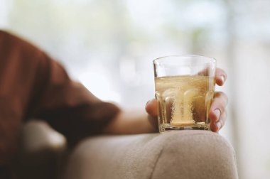 Fizzy tableti, genç adamın elindeki bir bardak suda çözülüyor.