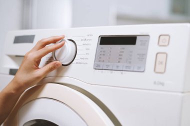 Giysiler için çamaşır makinesi seçen kadının yakın plan resmi
