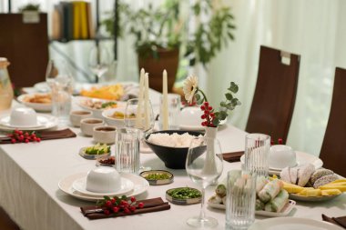 Bir kase pirinç ve yemek masasında çeşitli atıştırmalıklar.