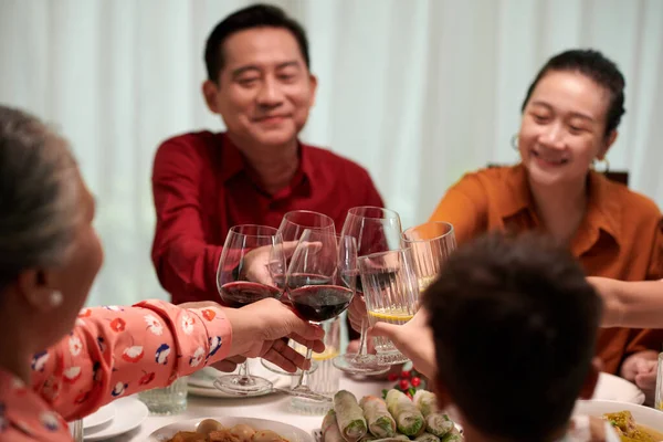 Big family toasting with wine glasses at family dinner