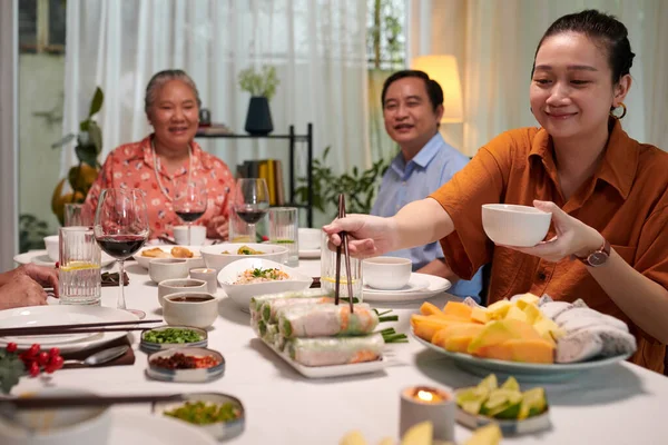 在家庭晚宴上吃春卷和酱汁的笑女人 — 图库照片