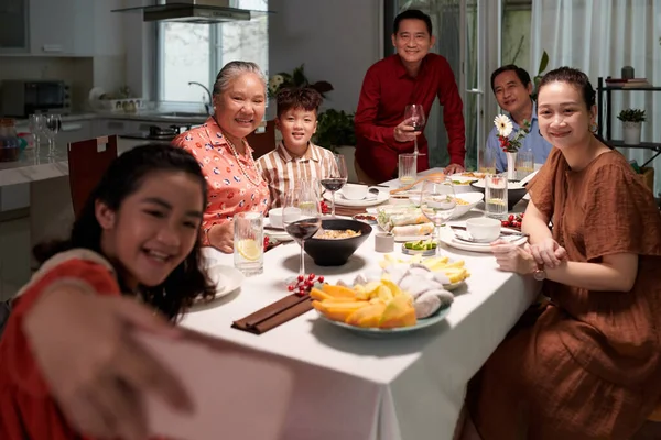 Hymyilevä Teini Tyttö Ottaa Selfie Perheensä Kanssa Päivällispöydässä — kuvapankkivalokuva