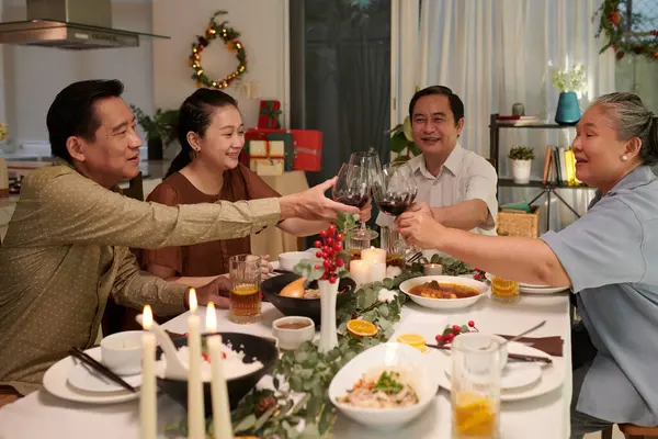 Vietnamese family enjoying celebrating Christmas together, drinking wine and eating traditional dishes