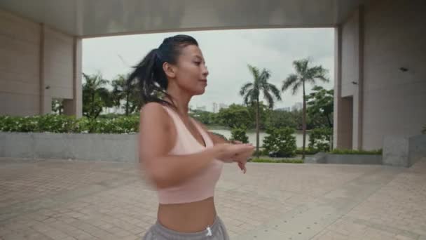 屋外で午前中に運動しながら温暖化する若い女性の中長いショット — ストック動画
