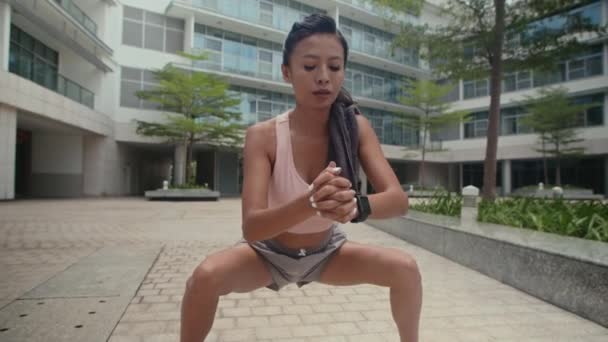 亚洲年轻女子在户外训练时伸展内腿肌肉的中长镜头 — 图库视频影像