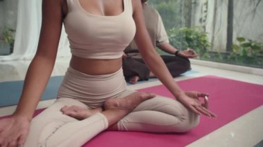 Çok kültürlü çiftin evde lotus pozisyonunda otururken gözleri kapalı meditasyon yaparken çekimini yukarı kaldır.