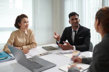 Bir grup iş adamı toplantıda proje geliştirme fikirlerini tartışıyor