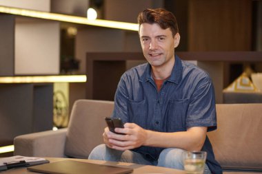 Ofis salonunda çalışan neşeli, olgun iş adamının portresi.