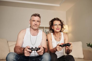 Büyüleyici olgun çift evde video oyunu oynamaktan zevk alıyor.
