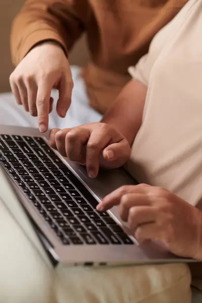 Close-up image of teenage boy explaining grandmother how to work on laptop he presented her