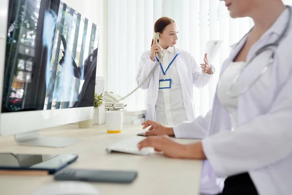 肺X線を調べた後 患者に電話する深刻な女性医師 — ストック写真
