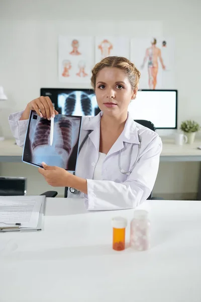 回復した患者の肺X線を示す若い女性一般開業医の肖像画 — ストック写真