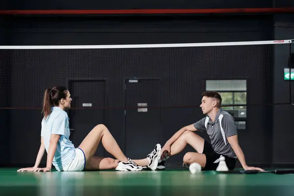 Jovem Casal Sentado Chão Net Discutindo Jogo Badminton — Fotografia de Stock