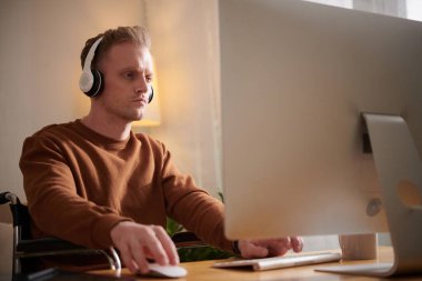 Gösterici zarif bir şekilde havadaki ipek rutini sırasında zorlu bir duruş sergiliyor, canlı sahne ışıkları altında zarif bir hareket ve yoğun bir odaklanma ile yıkanmış.