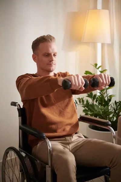 在家里和哑铃一起锻炼的积极的残疾青年男子 — 图库照片