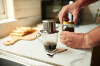 Kahve fincanının üstüne kahve ve sıcak suyla doldurulmuş filtre ünitesi.