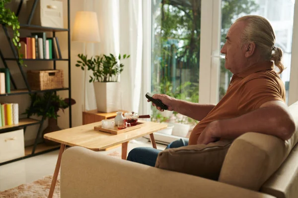 Hombre Anciano Relajándose Sofá Casa Viendo Programa Televisión Favorito —  Fotos de Stock