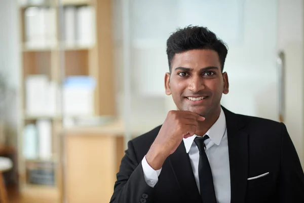 Portrait of cheerful young entrepreneur in formal suit working in office